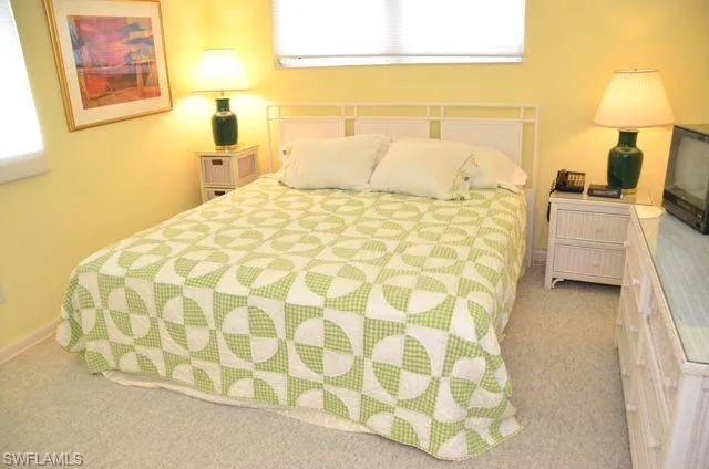 a bedroom with a bed and lamp on the dresser