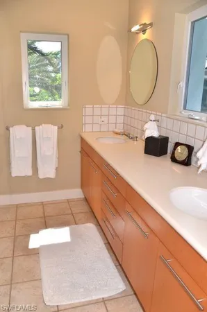 a bathroom with a double vanity sink and a mirror