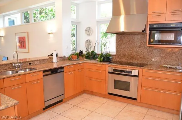 a kitchen with stainless steel appliances granite countertop a sink stove and cabinets