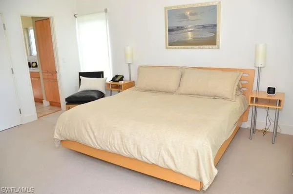 a large bed sitting in a bedroom next to a small bathroom
