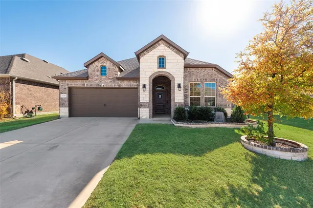 a front view of a house with a yard and trees