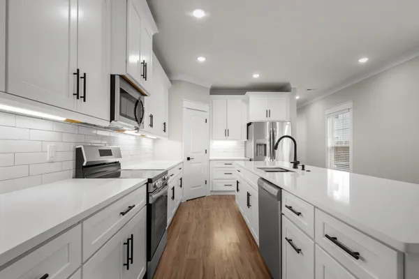 a large kitchen with stainless steel appliances lots of counter space sink and cabinets