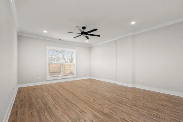 an empty room with wooden floor and windows