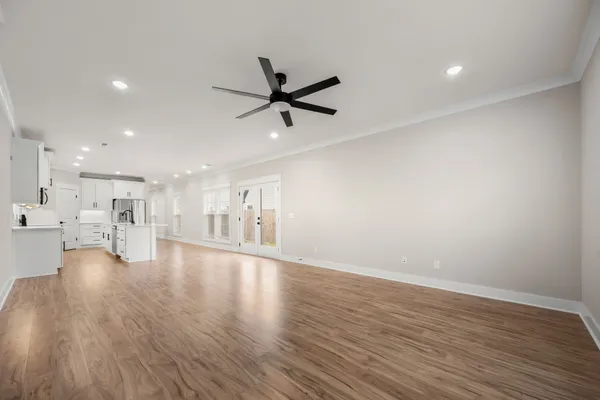 a view of empty room with wooden floor and ceiling fan