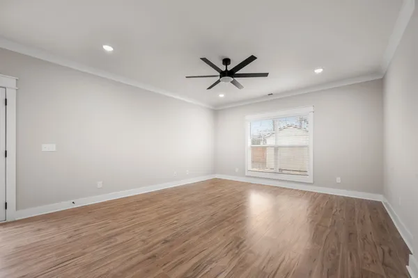 an empty room with wooden floor and windows