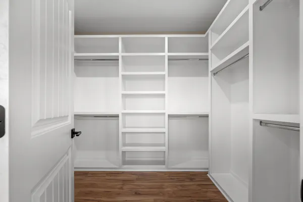 a view of walk in closet with empty racks