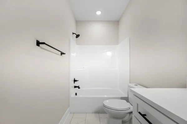 a bathroom with a granite countertop sink a toilet and shower
