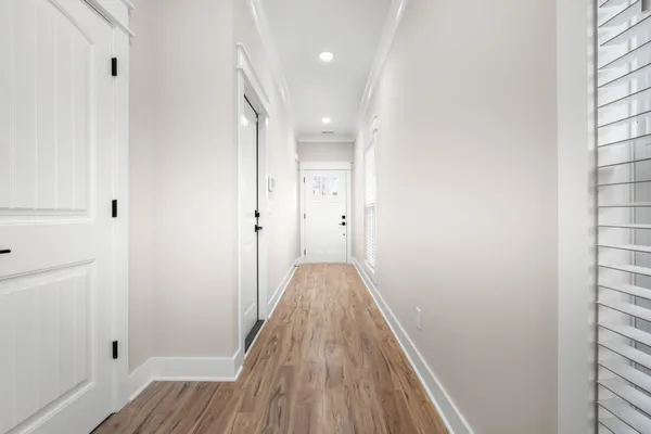 a view of a hallway with wooden floor and staircase
