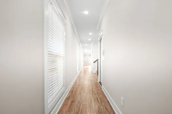 a view of a hallway with wooden floor