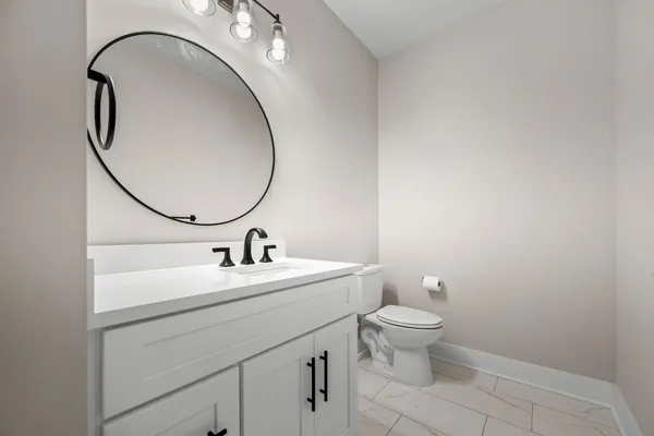 a bathroom with a sink a toilet and a mirror
