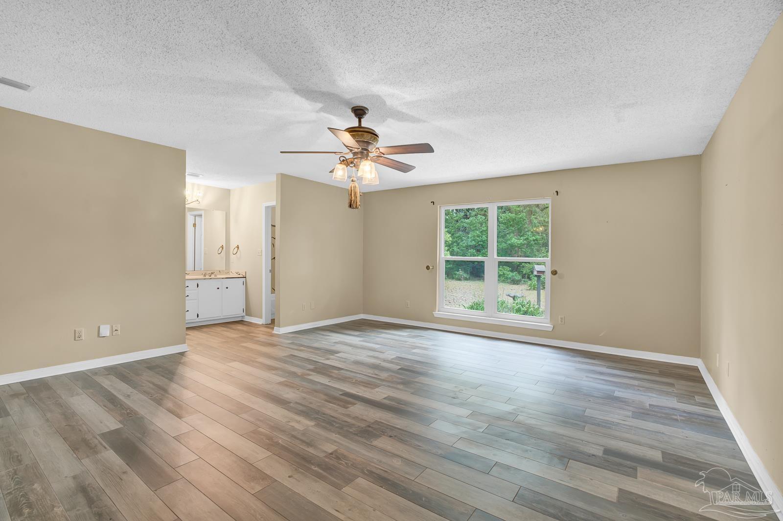 5036 Hamilton Lane Pace, FL 32571 - Photo 17 of 37 a view of an empty room with a window and wooden floor