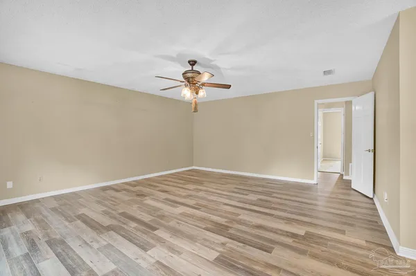 an empty room with windows and chandelier