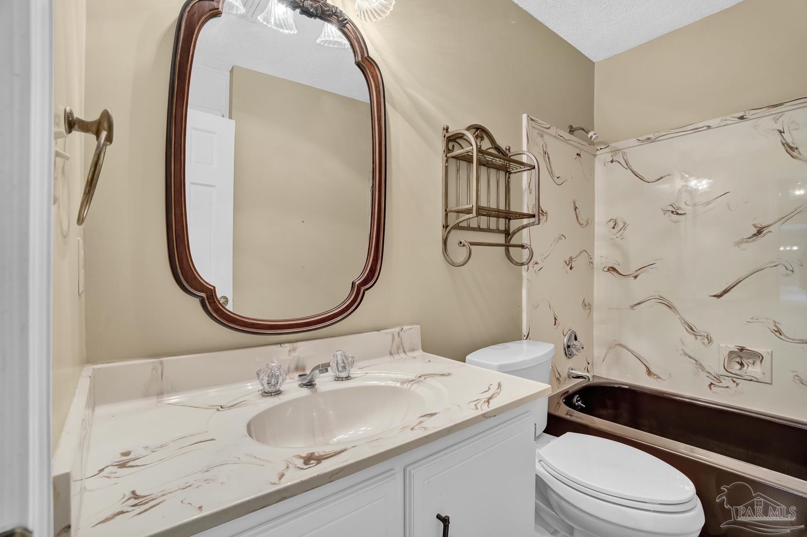5036 Hamilton Lane Pace, FL 32571 - Photo 22 of 37 a bathroom with a sink a toilet and a mirror