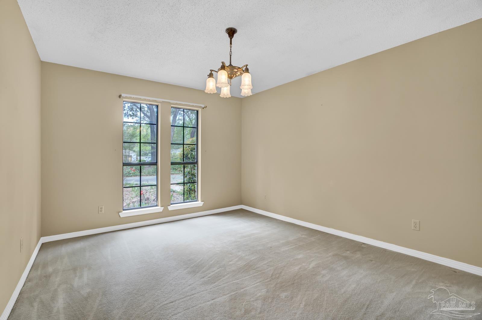 5036 Hamilton Lane Pace, FL 32571 - Photo 25 of 37 an empty room with windows and chandelier