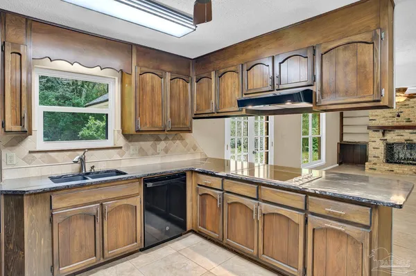 a bathroom with a granite countertop sink a toilet and mirror