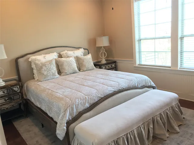 a bedroom with a bed and a large window