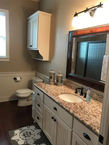 a bathroom with a granite countertop sink and a mirror