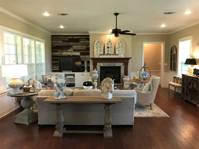 a living room with fireplace furniture and a large window