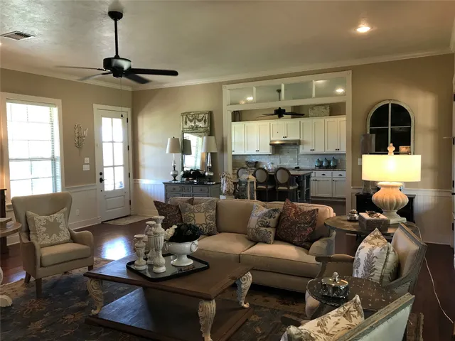 a living room with furniture kitchen and a chandelier