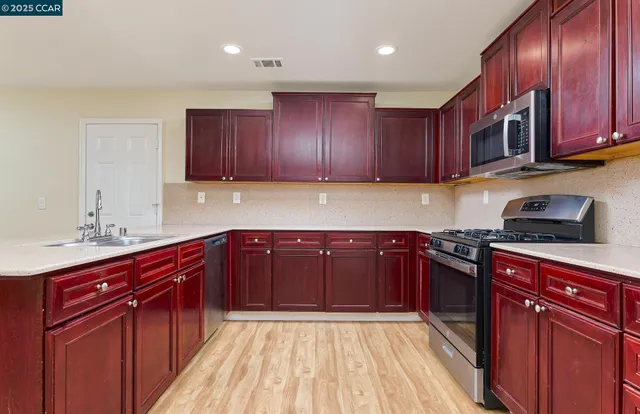 a kitchen with stainless steel appliances granite countertop wooden cabinets a sink and dishwasher