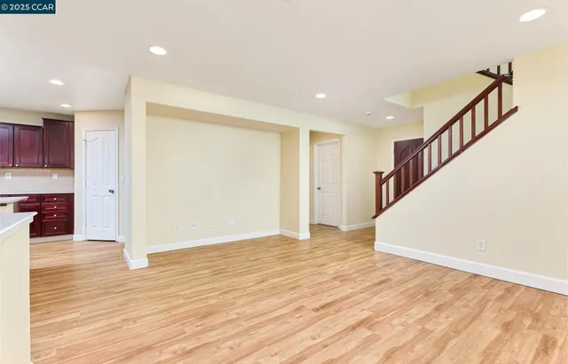 a view of a hallway with wooden floor and staircase