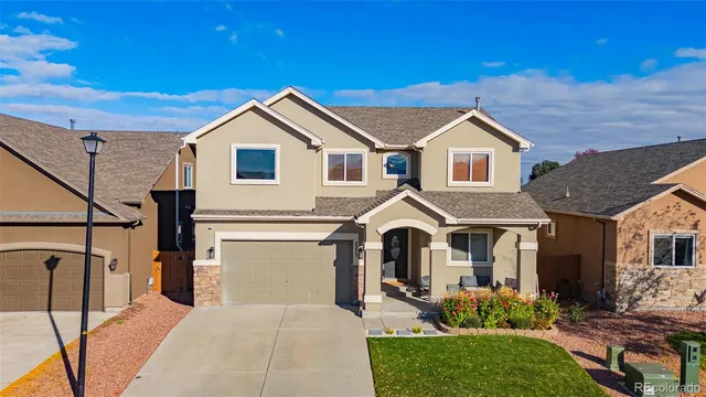 a front view of a house with yard and parking