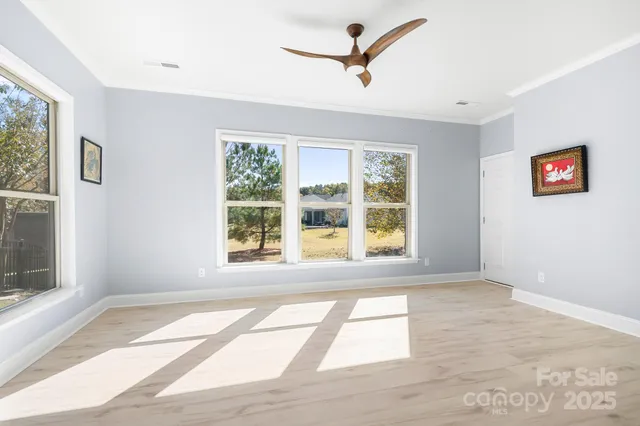 a view of an empty room with a window and a ceiling fan