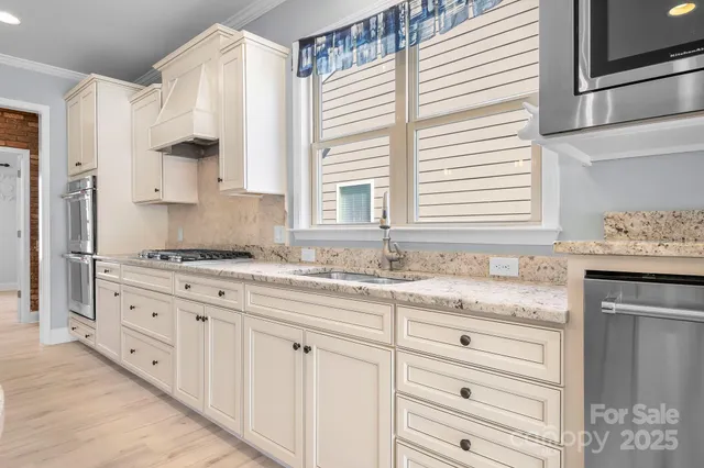 a kitchen with granite countertop white cabinets and a sink