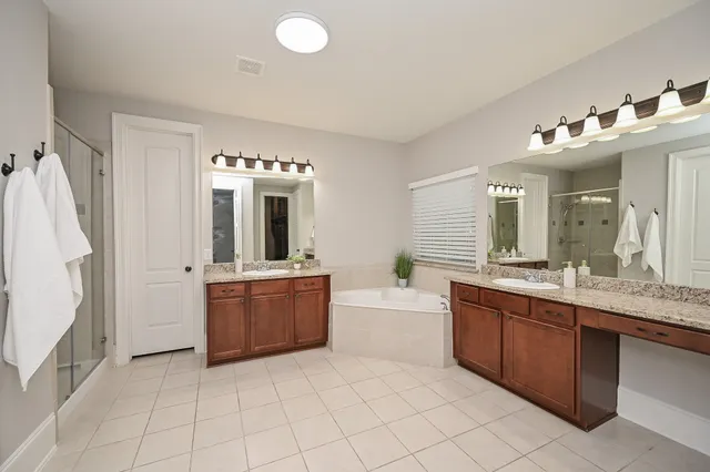 a large bathroom with a tub sink and mirror