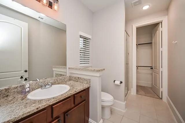 a bathroom with a granite countertop sink toilet and shower