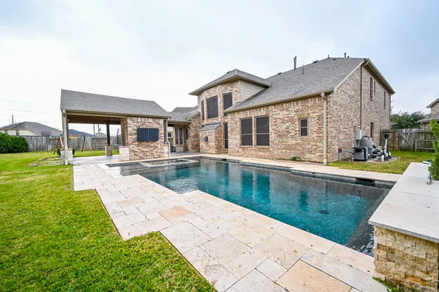 a view of swimming pool with outdoor seating and a yard
