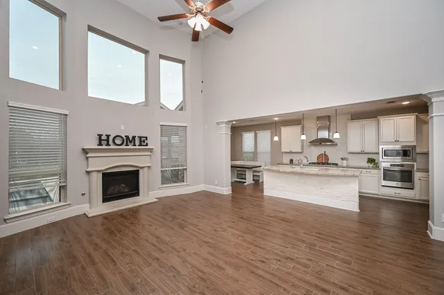 a view of a kitchen with a stove wooden cabinets and entryway