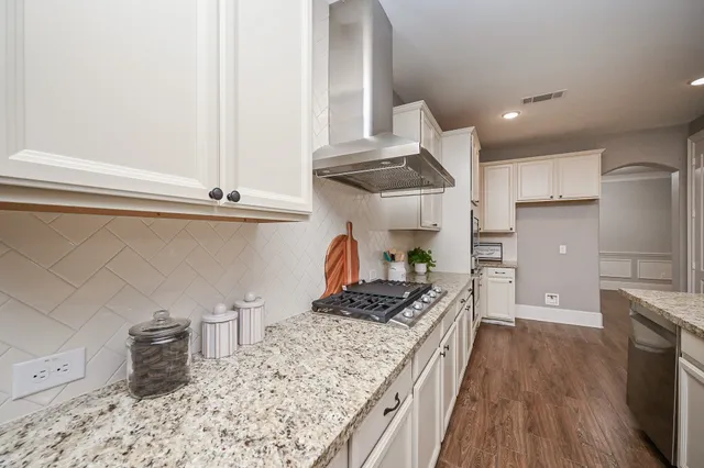 a kitchen with granite countertop a stove and a wooden floors