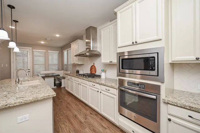 a kitchen with stainless steel appliances granite countertop a stove oven and a white cabinets