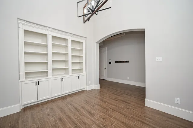 a view of empty room with wooden floor and cabinet
