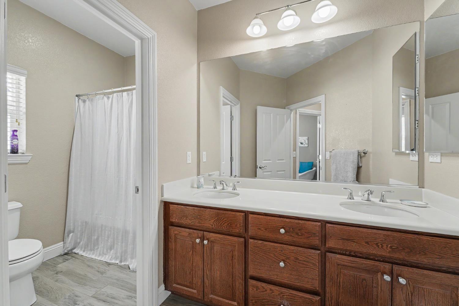 1223 East Springer Drive Turlock, CA 95382 - Photo 35 of 48 a bathroom with a double vanity sink toilet and a mirror