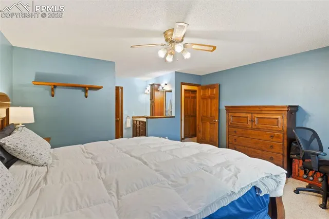 a bedroom with a bed and dresser with wooden floor