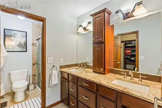 a bathroom with a granite countertop sink toilet and shower