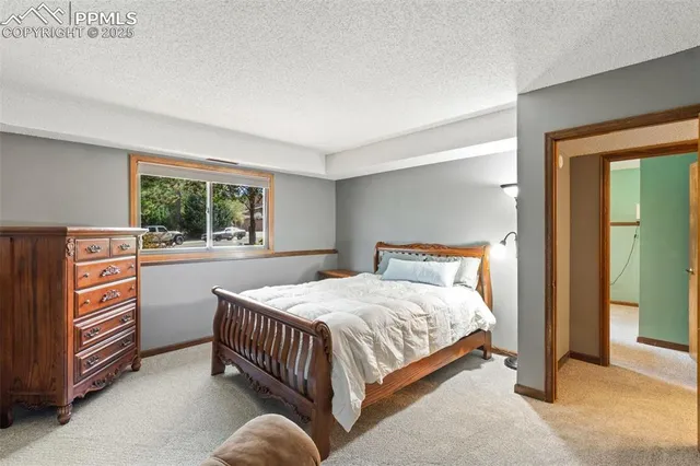 a bedroom with a bed and a dresser next to a window