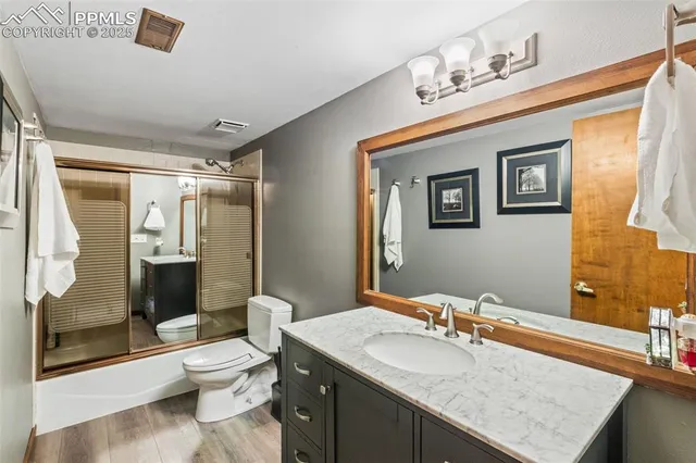 a bathroom with a granite countertop sink toilet and shower