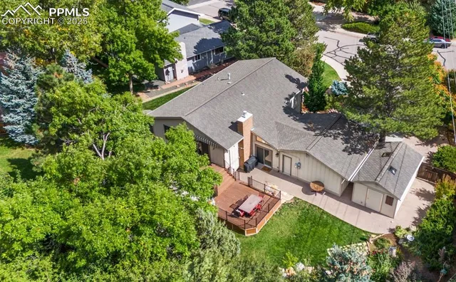 an aerial view of residential house with outdoor space and trees all around