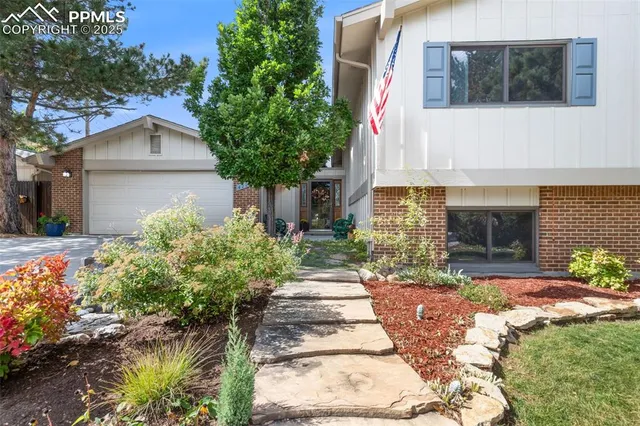 a front view of a house with a yard and a garden