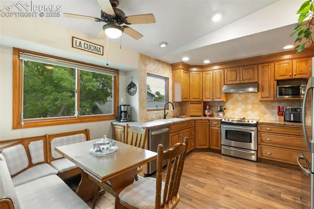 a kitchen with a stove a sink dishwasher a kitchen island with a stove and white cabinets