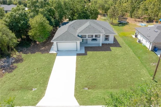 a aerial view of a house with swimming pool and large trees