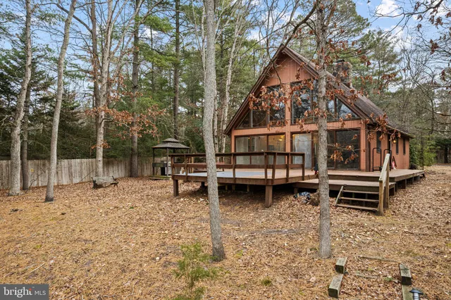 a view of a house with backyard wooden fence and a tree
