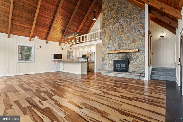 a view of empty room with wooden floor and fireplace