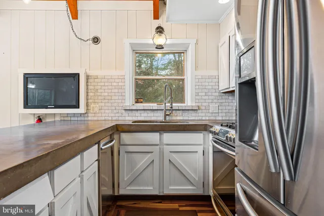 a kitchen with stainless steel appliances a sink and a microwave