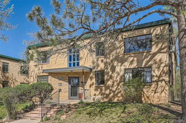 a front view of a house with a tree