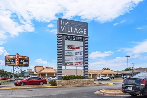 a city street filled with lots of traffic and parked cars