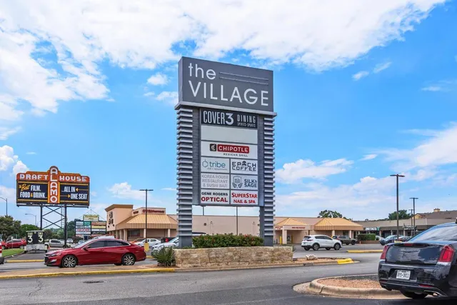 a city street filled with lots of traffic and parked cars